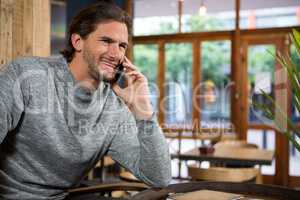 Man talking on smart phone in coffee shop