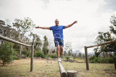 Fit man balancing on hurdles during obstacle course training