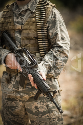 Mid section of military soldier holding a rifle