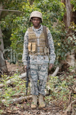 Portrait of confident military soldier standing with rifle