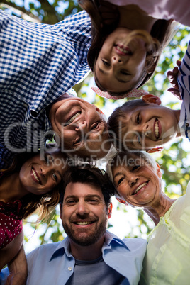 Multi generation family forming a huddle in park