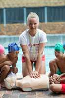 Lifeguard demonstrating children during rescue training