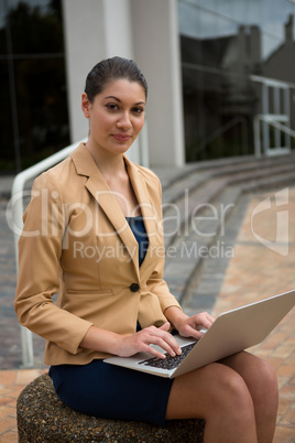 Portrait of smiling businesswoman using laptop