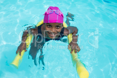 High angle view of girl swimming with pool noodle