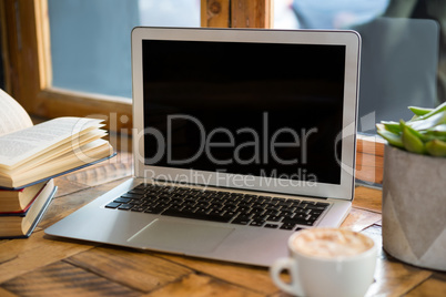 Laptop with blank screen in coffee shop