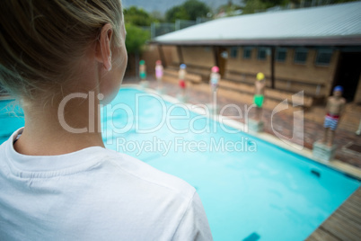 Female instructor standing at poolside