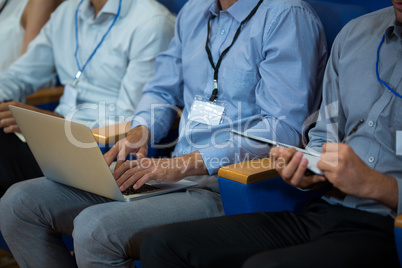 Business executives participating in a business meeting using electronic devices