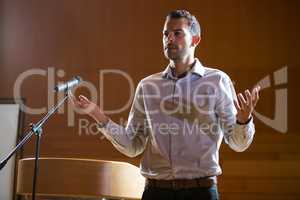 Business executive gesturing while giving a speech