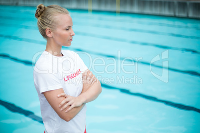 Female lifeguard standing at poolside