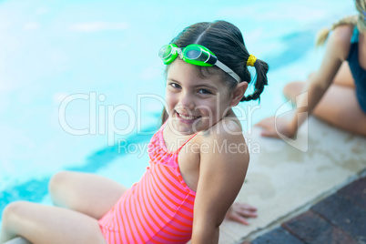 Cute little girl resting at poolside