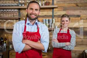 Smiling male barista with female colleague in coffee shop