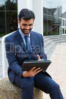 Smiling businessman using digital tablet