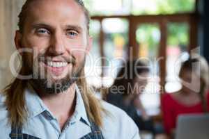 Portrait of confident male barista in coffee shop