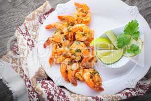 Fried Prawns with lemon served on a wooden surface.