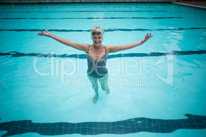 Carefree senior woman swimming in pool