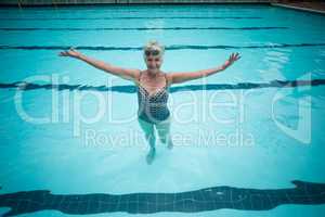 Carefree senior woman swimming in pool