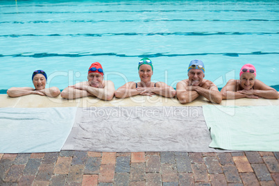 Senior swimmers leaning on poolside