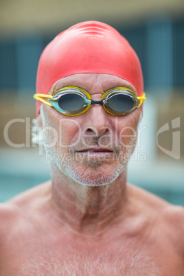 Shirtless senior swimmer wearing goggles