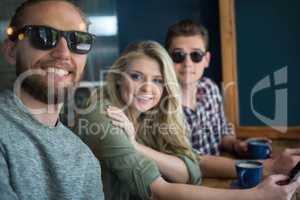 Happy male and female friends at table in coffee house