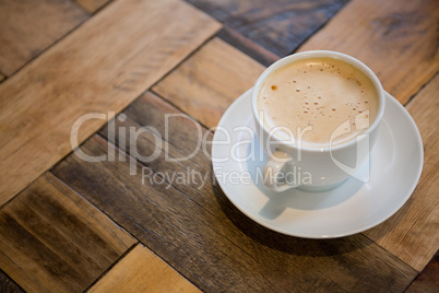 Coffee cup on wooden table in cafeteria