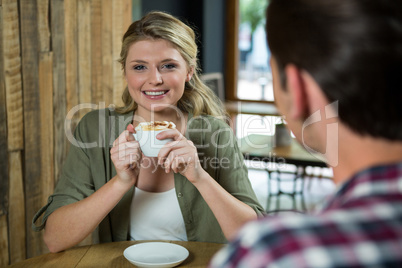 Smiling woman having coffee with man in cafe