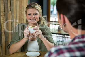 Smiling woman having coffee with man in cafe
