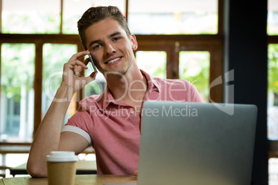 Handsome man talking on mobile phone in cafe