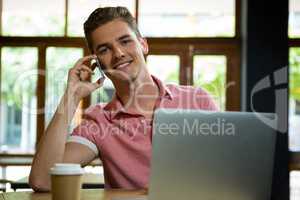 Handsome man talking on mobile phone in cafe