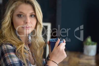 Beautiful young woman holding coffee cup in cafe