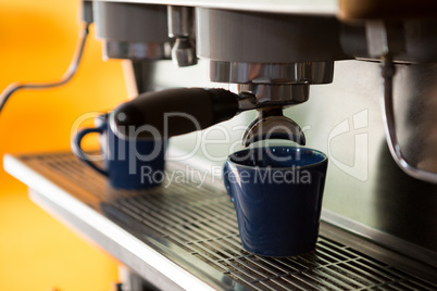 Machine making cup of coffee in cafe