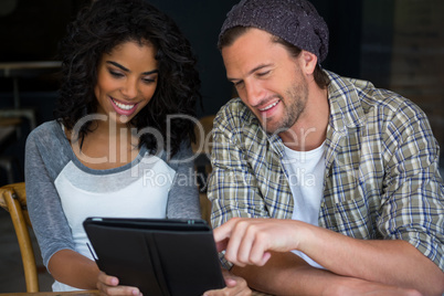 Friends using digital tablet in coffee house