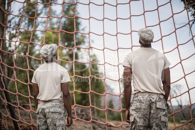 Military soldiers looking at net during obstacle course