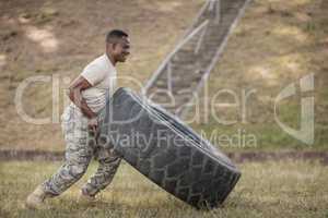 Determined military soldiers exercising with tyre