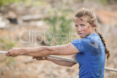 Woman playing tug of war during obstacle course
