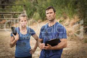 Trainer and woman standing together during obstacle course