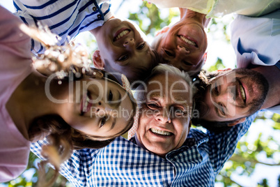 Multi generation family forming a huddle in park