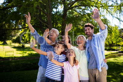 Multi generation family waving hand in air at the park