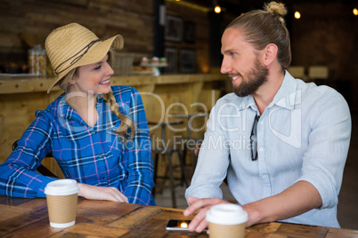 Smiling couple talking at table in coffee shop