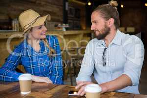 Smiling couple talking at table in coffee shop