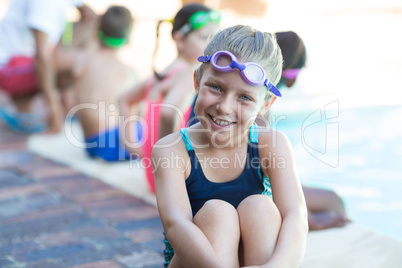 Smiling little boy sitting at poolside