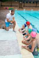 Instructor assisting senior swimmers at poolside