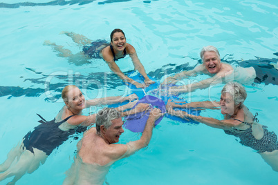 Cheerful trainers and senior swimmers in pool