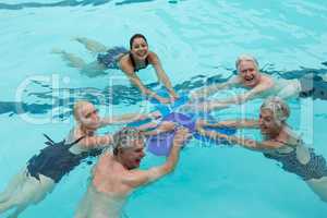 Cheerful trainers and senior swimmers in pool