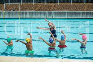 Instructor teaching children in swimming pool