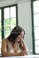 Cheerful woman using mobile phone in restaurant