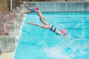 Children diving in water at poolside
