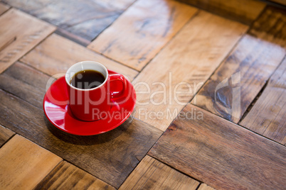 Red cup of espresso served on table