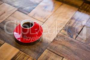Red cup of espresso served on table