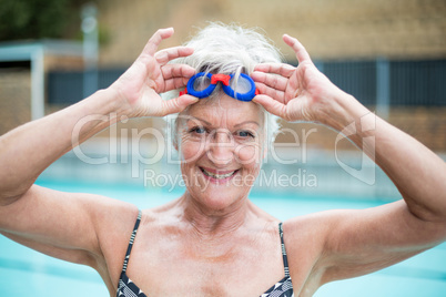 enior woman holding swimming goggles