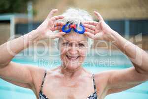 enior woman holding swimming goggles